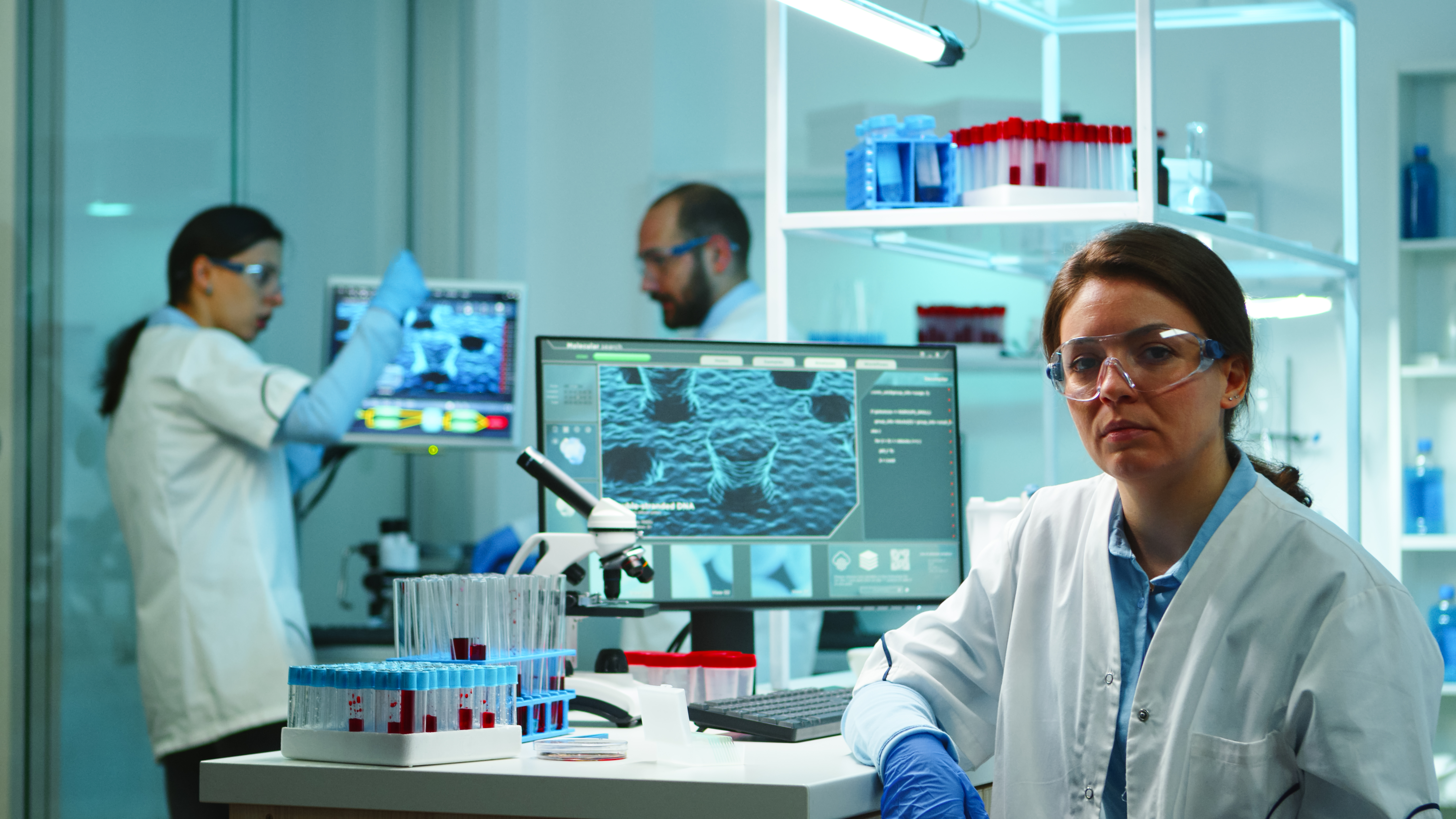 portrait-scientist-nurse-looking-tired-camera-sitting-modern-equipped-laboratory-late-night-team-specialists-examining-virus-evolution-using-high-tech-research-vaccine-development